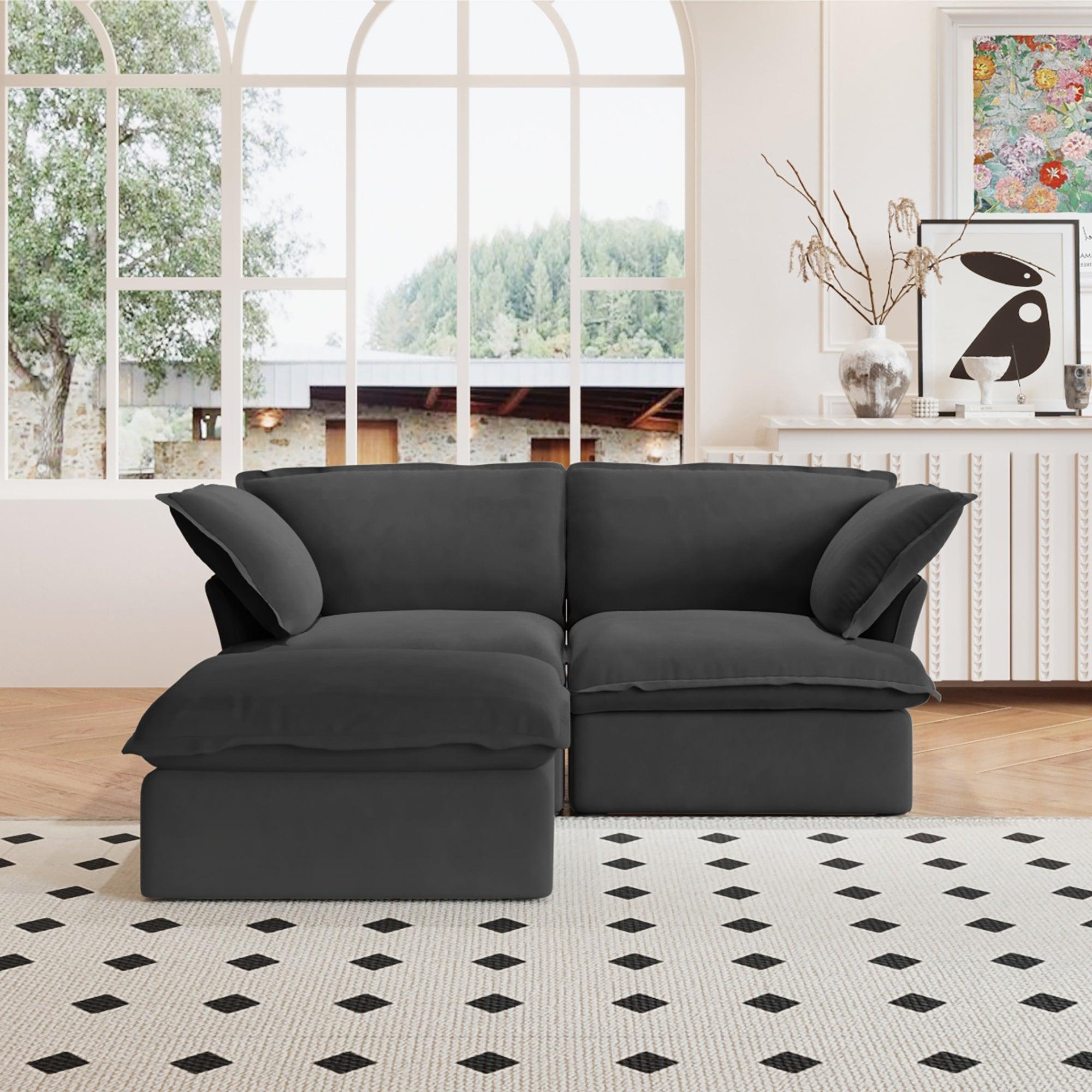 A black chaise lounge loveseat linen sectional sofa with a modular design and a storage ottoman, placed on a patterned rug in a bright living space.