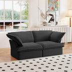 A black loveseat linen sectional sofa with modular design placed on a patterned rug in a bright living room setting.