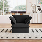 A black linen armchair with a solid frame and washable covers, placed on a patterned rug in a bright room.