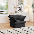 A black linen armchair with a solid frame and washable covers, placed on a patterned rug in a bright room.