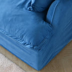 Close-up of the corner cushion and base of a blue velvet sofa