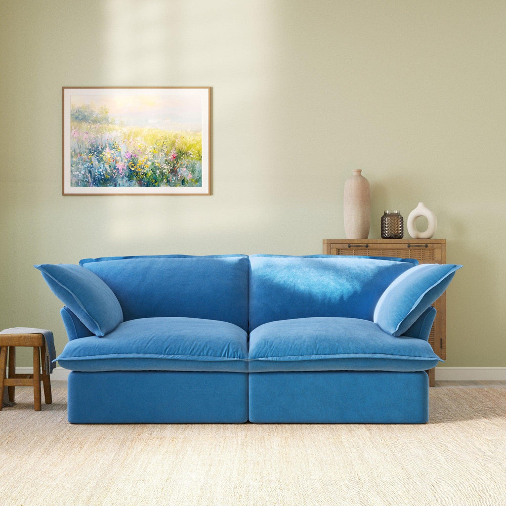 Modular blue velvet loveseat sofa with curved armrests, front
