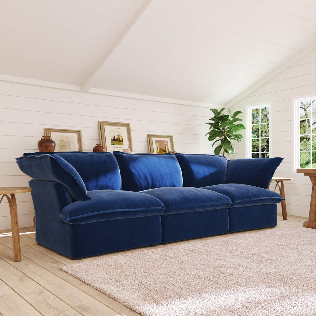 Dark blue 3-seater sofa in a room with wooden floor and white walls