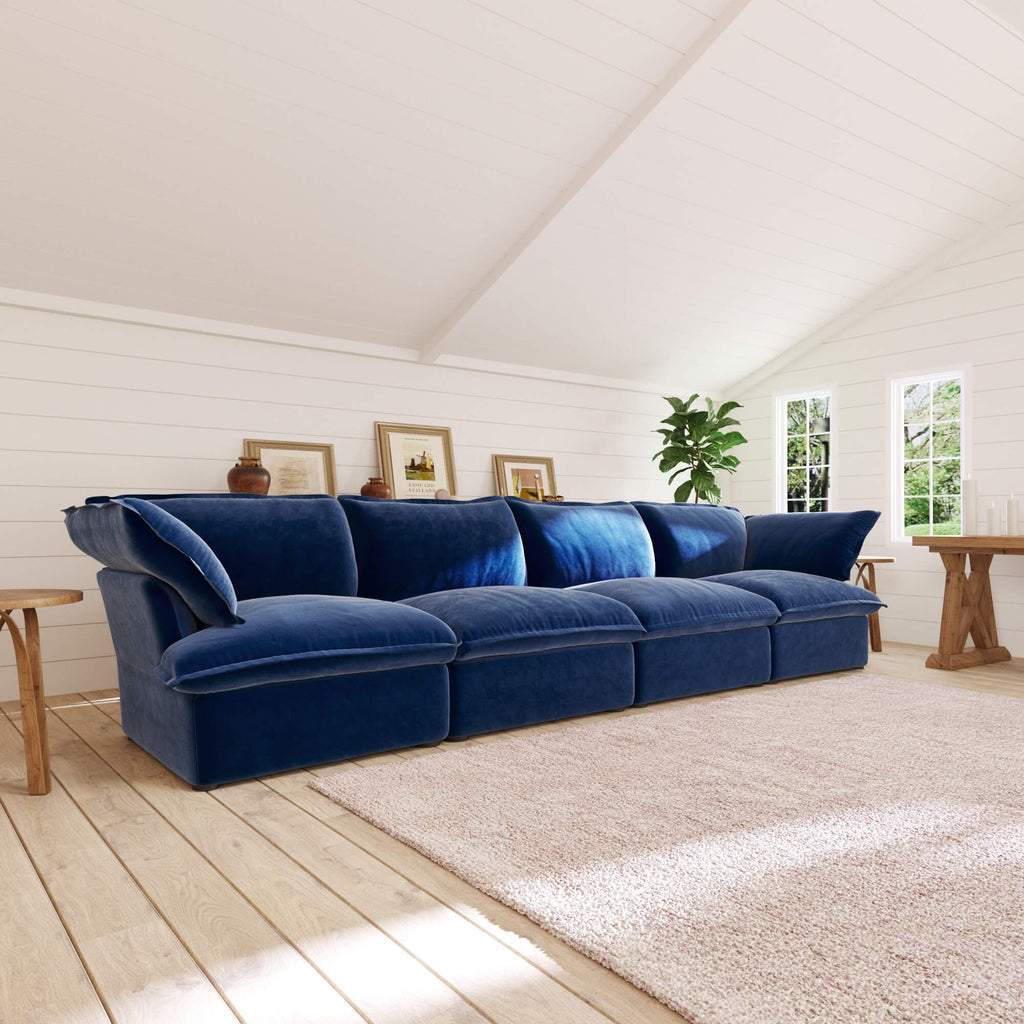 Dark blue 4-seat sectional sofa in a room with wooden floor and white walls
