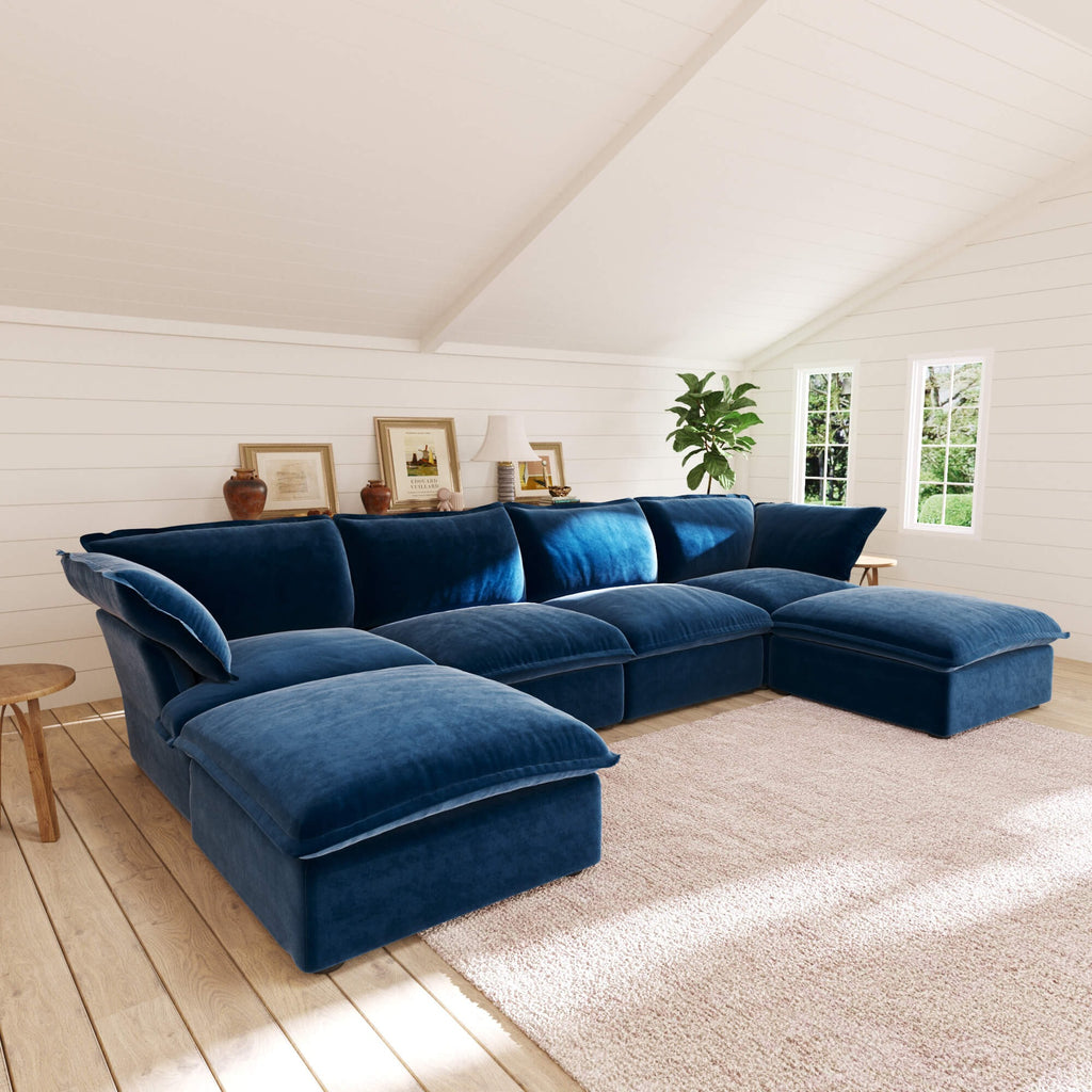 Dark blue U-shaped sectional sofa in a living room with wooden floor and white walls