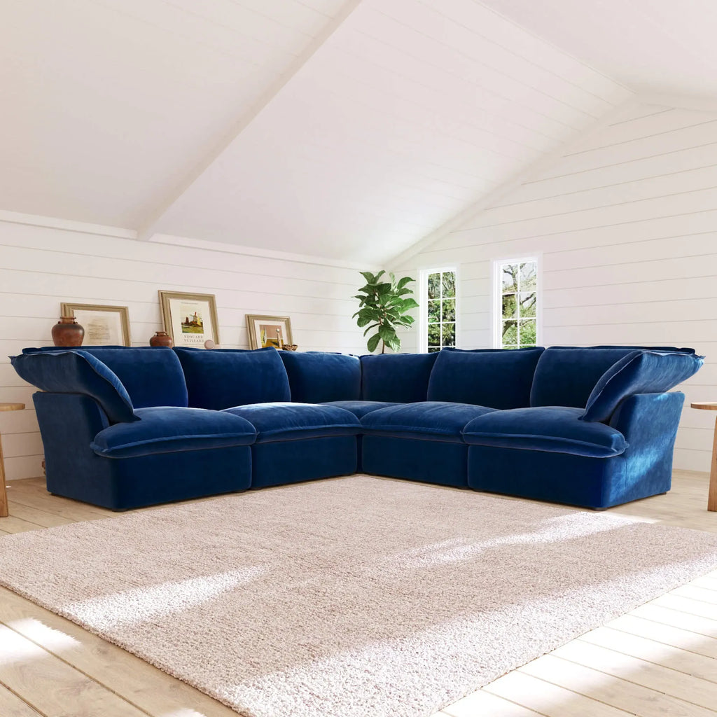 Dark blue corner sectional sofa in a room with white walls and wooden floor.