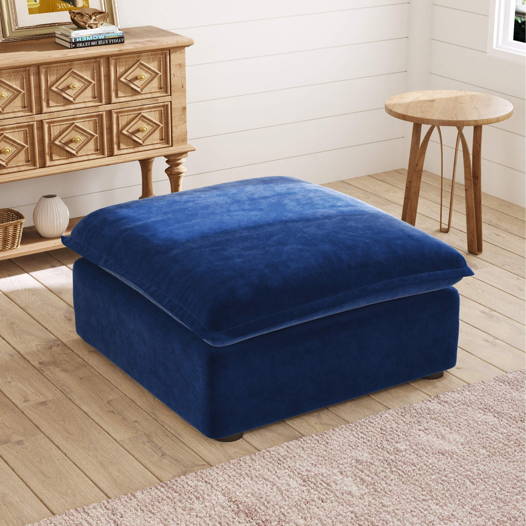Dark blue ottoman in a room with wooden furniture and a white wall.