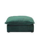 A green velvet pouf ottoman with plush upholstery, shown with a removable cover.