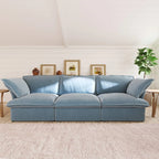 Light blue 3-seater sofa in a living room with framed pictures and a plant.