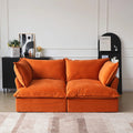 Orange velvet 2-seater sofa with flared arms and washable covers.