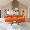 Orange 3-seat sofa in a living room with a fireplace and decorative elements.