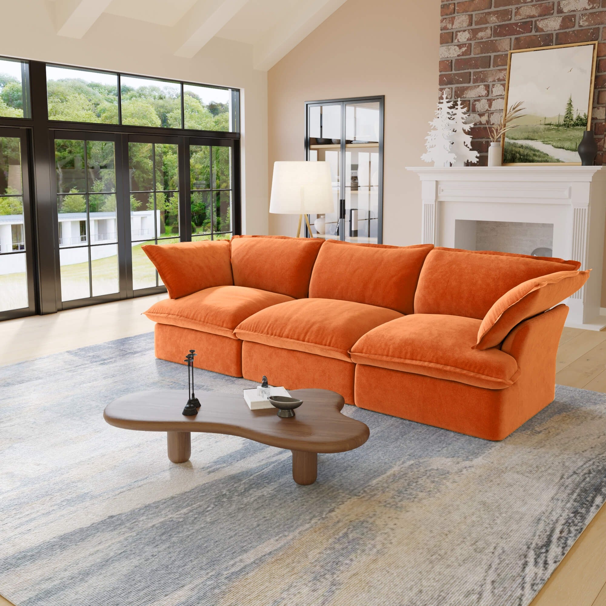 Orange 3-seat sofa in a living room with large windows and a fireplace.