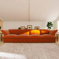 Orange sectional 4-seat sofa in a living room with a neutral color palette