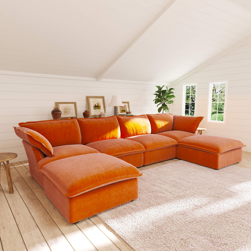 Orange U-shaped sectional sofa in a room with wooden floor and white walls
