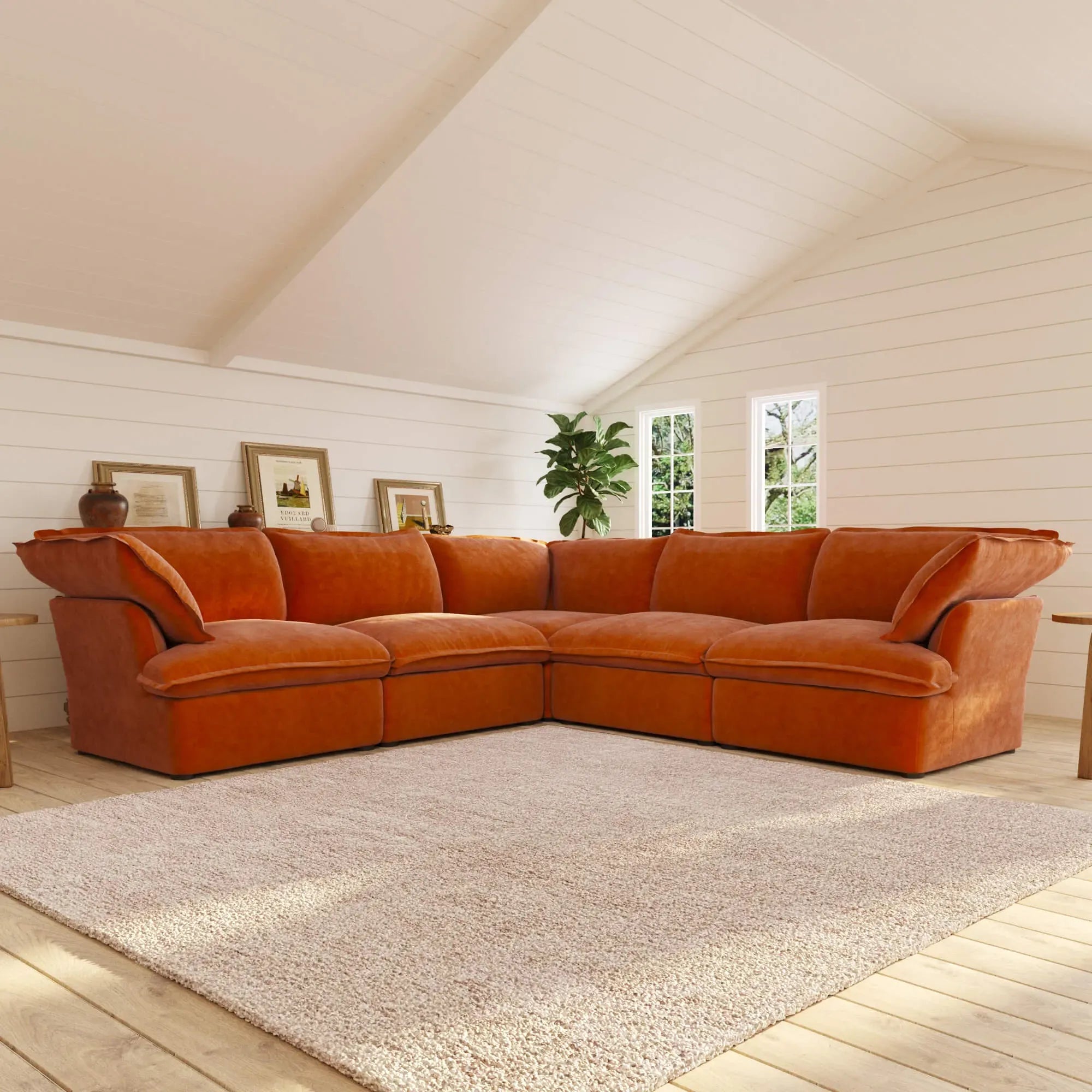 Orange corner sectional sofa in a room with light wood flooring and white walls.