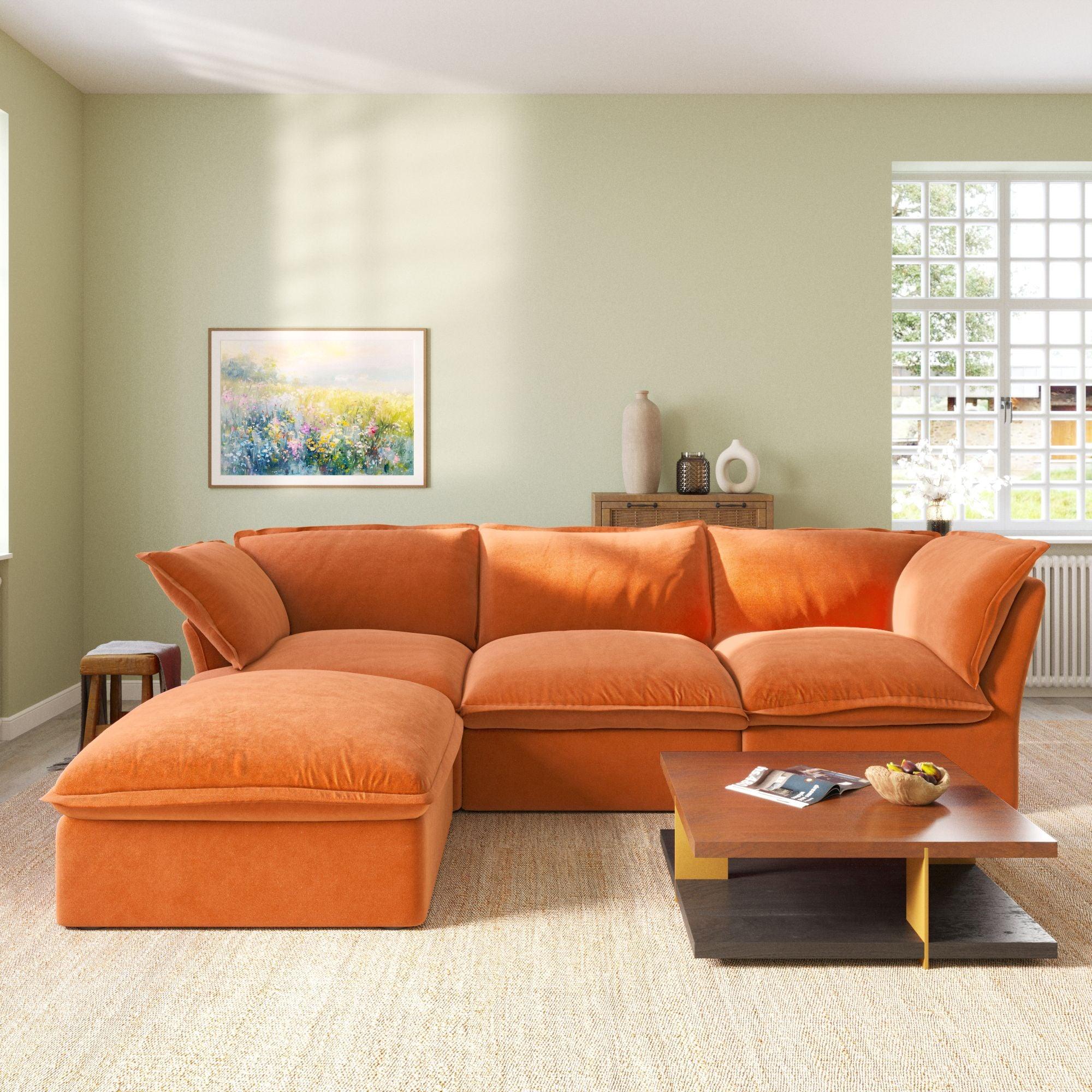 An L-shaped velvet sectional sofa in orange color, with a replaceable cover, arranged in a living room setting.