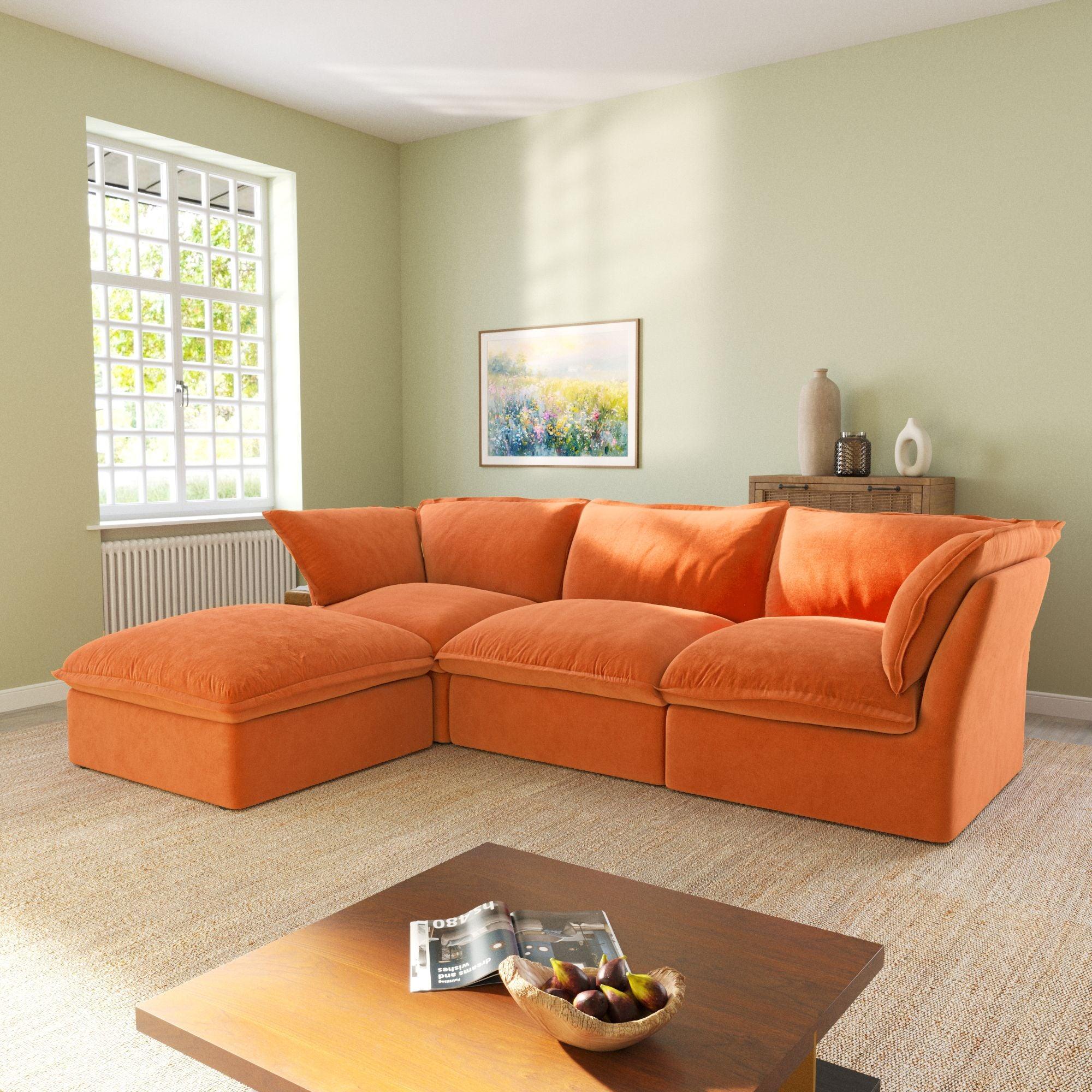 An L-shaped velvet sectional sofa in orange color, with a replaceable cover, arranged in a living room setting.