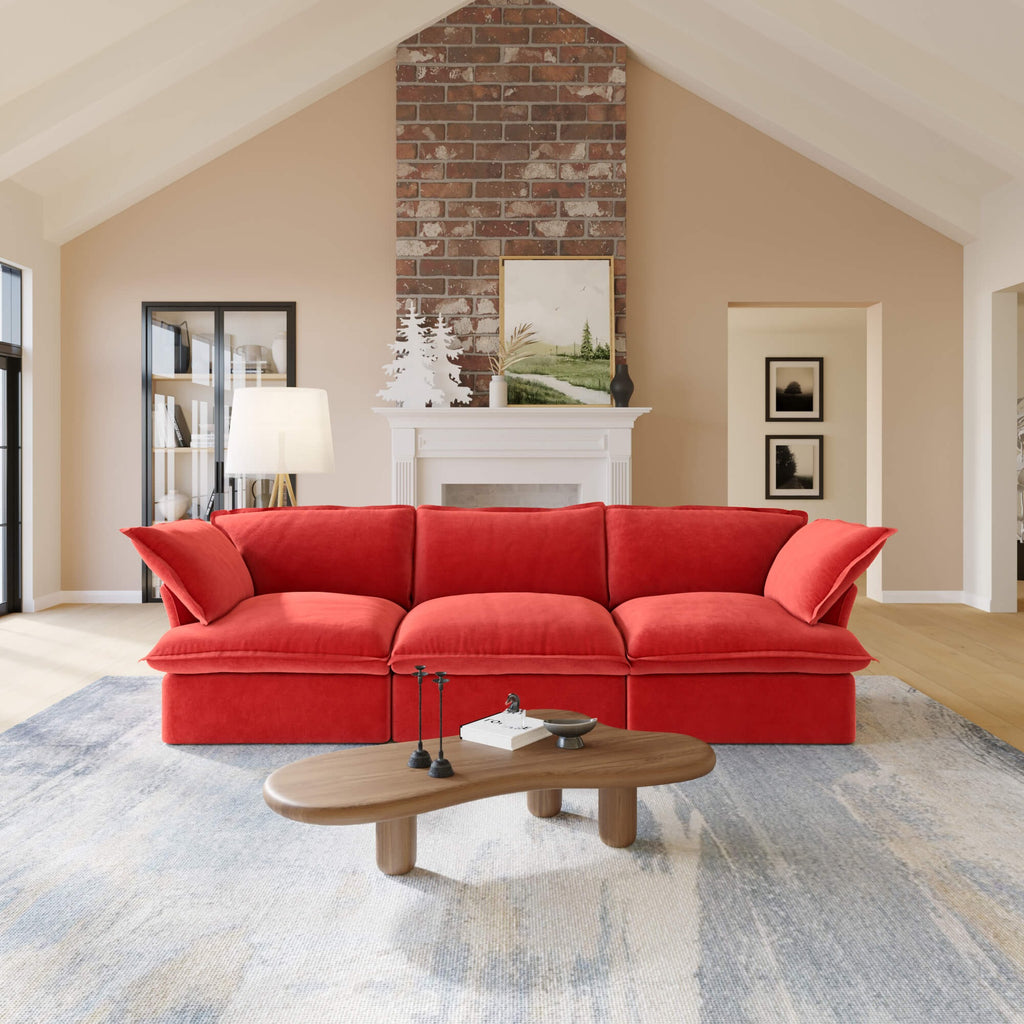 Red 3-seat sofa in a living room with a coffee table and decorative items.