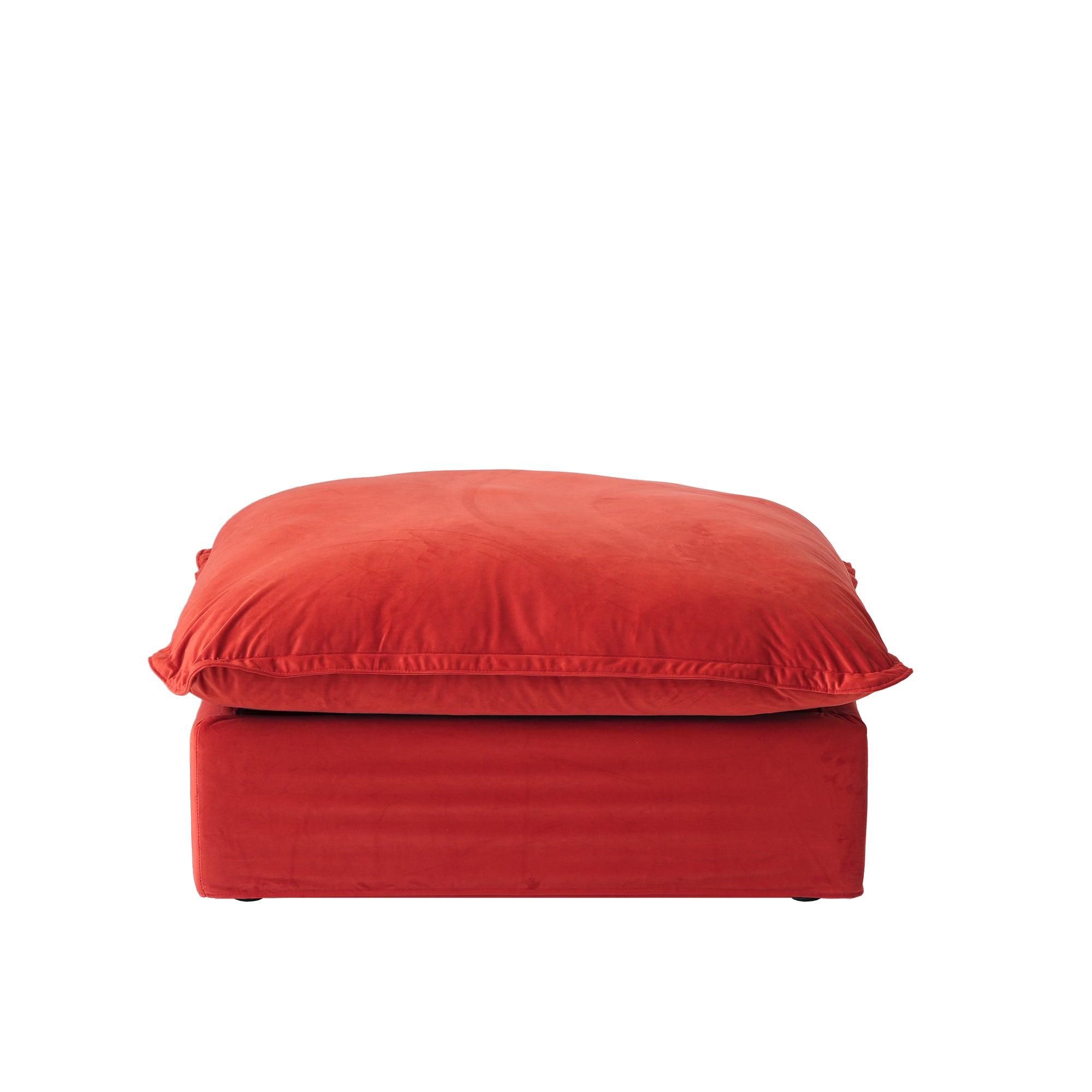 A red velvet pouf ottoman with plush upholstery, shown with a removable cover.