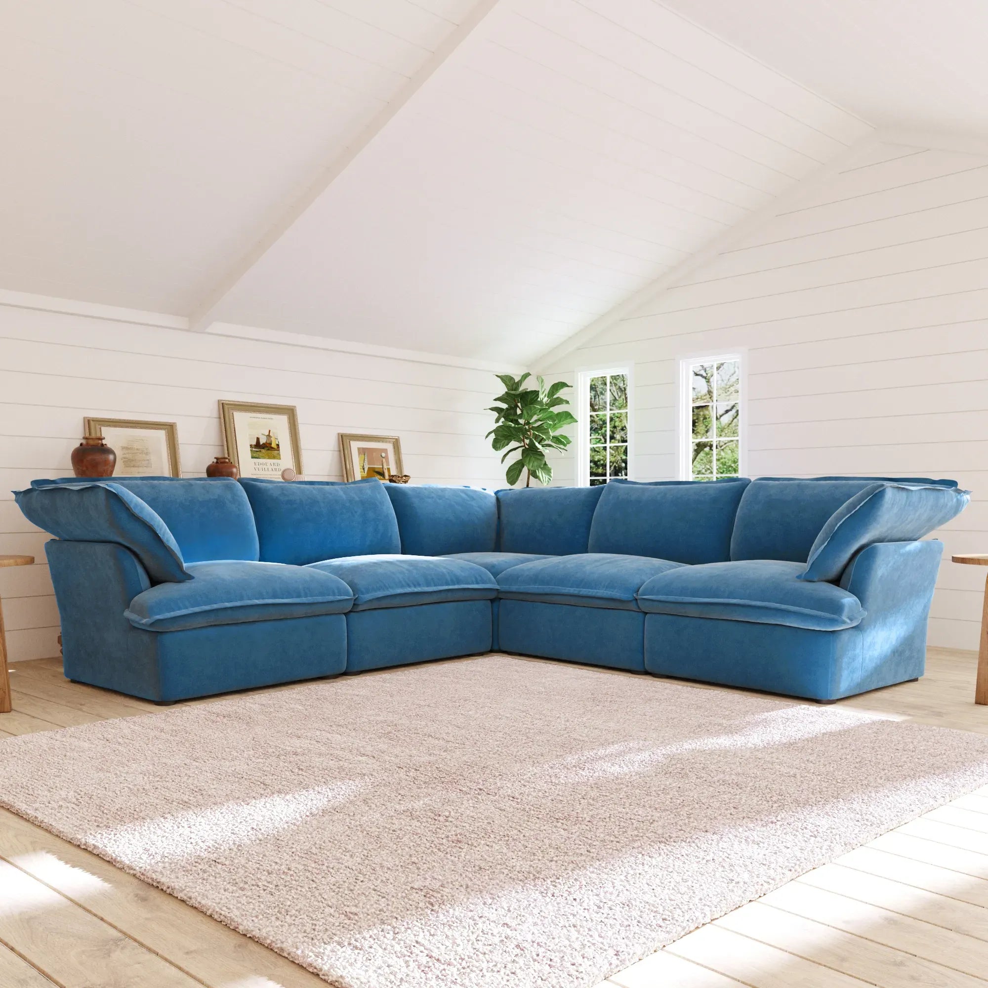 Sky blue corner sectional sofa in a living room with a white wall and window.