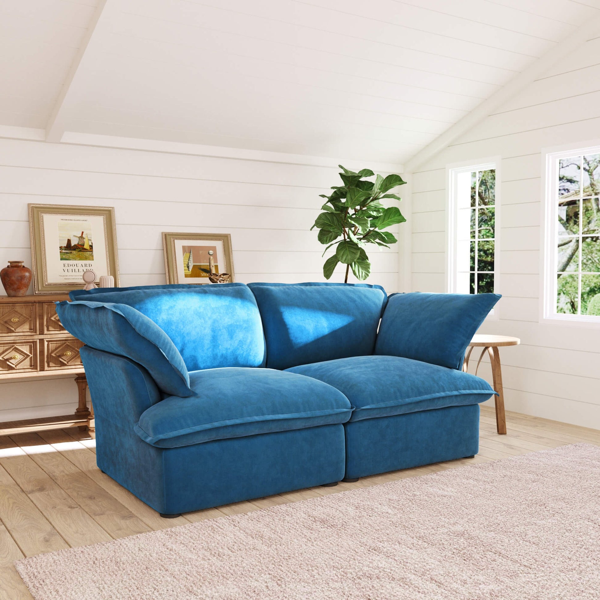 Sky blue loveseat sofa in a living room with white walls, a wooden side table, and a plant.
