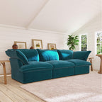 Teal 3-seat sofa in a living room with wooden floor and white walls