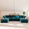 Teal U-shaped sectional sofa in a living room with white walls and wooden floor.