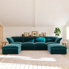 Teal U-shaped sectional sofa in a living room with white walls and wooden floor.