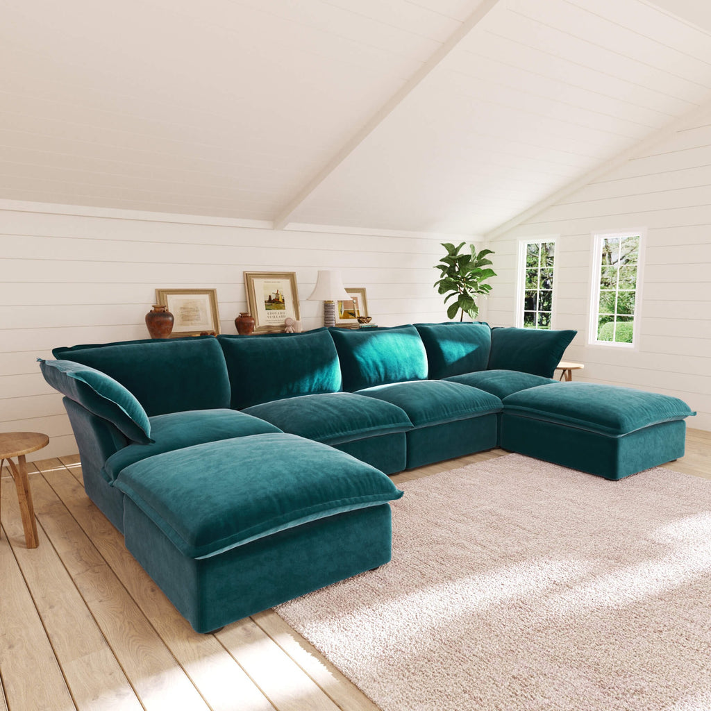 Teal U-shaped sectional sofa in a living room with wooden floor and white walls
