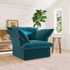 Teal armchair in a living room with a plant and window in the background