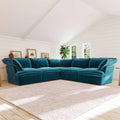 Teal corner sectional sofa in a living room with white walls and a large window.