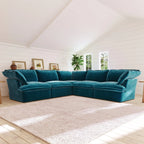 Teal corner sectional sofa in a living room with white walls and a large window.