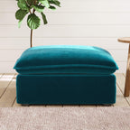 Teal ottoman with a plant and wooden stool in the background