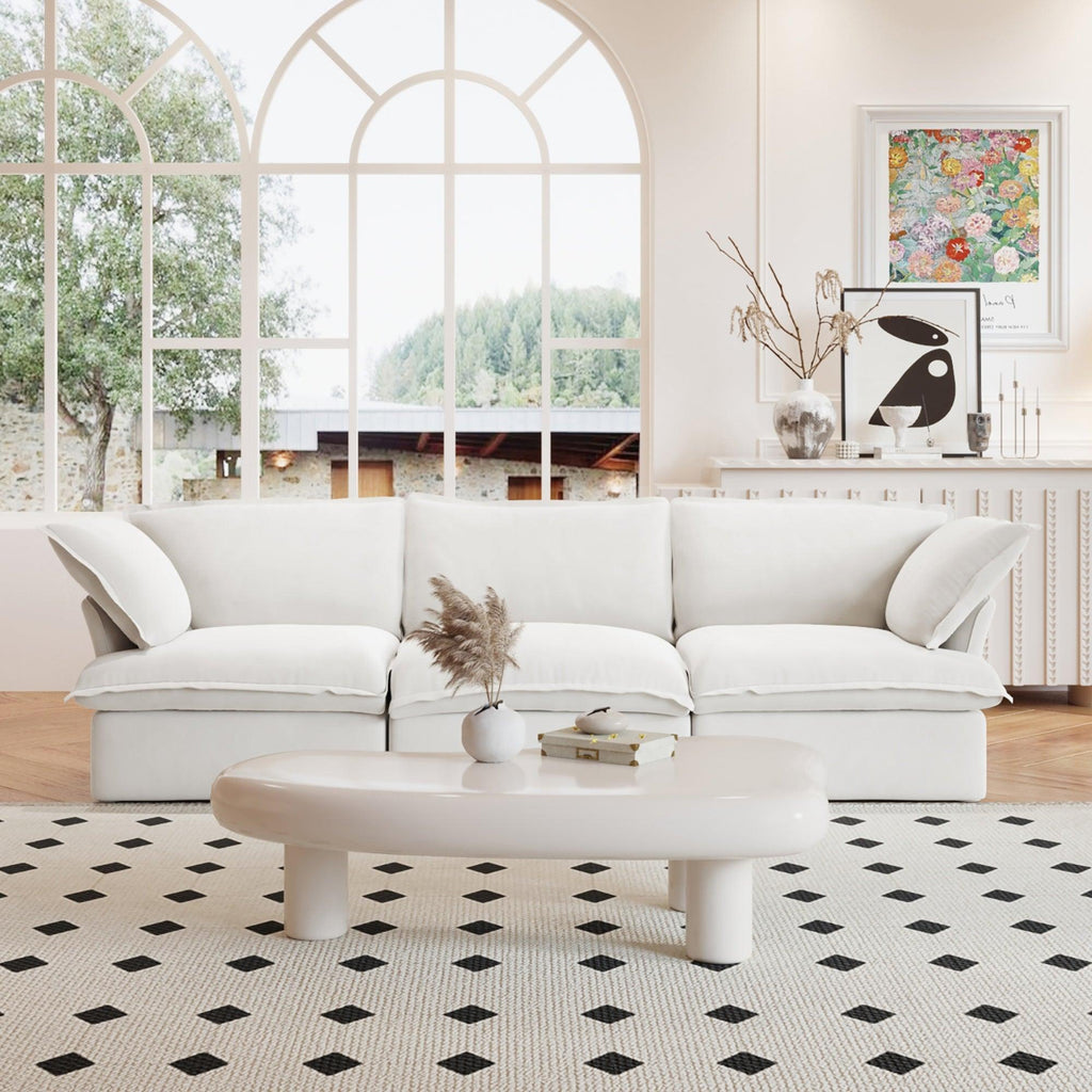 A white 3-seater linen sectional sofa in a modern living room setting with deep seating.