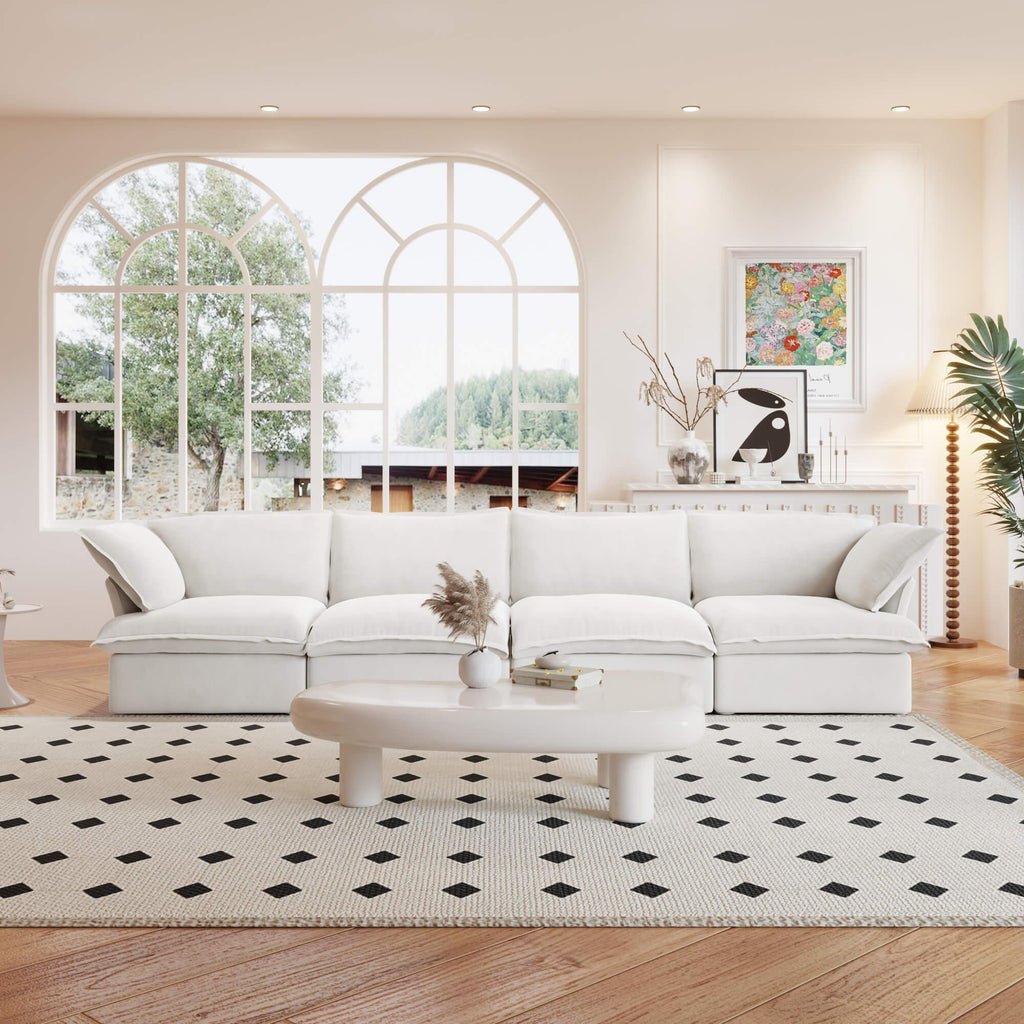 A white linen 4-seat sectional sofa arranged in a living room setting with deep seating.