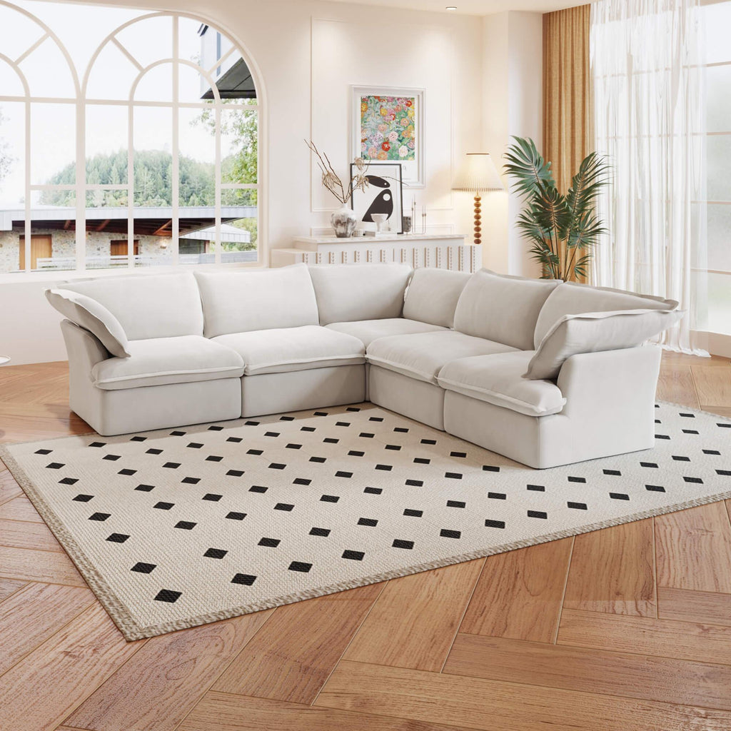 A white 5-piece corner linen sectional sofa arranged in a living room setting with a patterned rug on the floor.