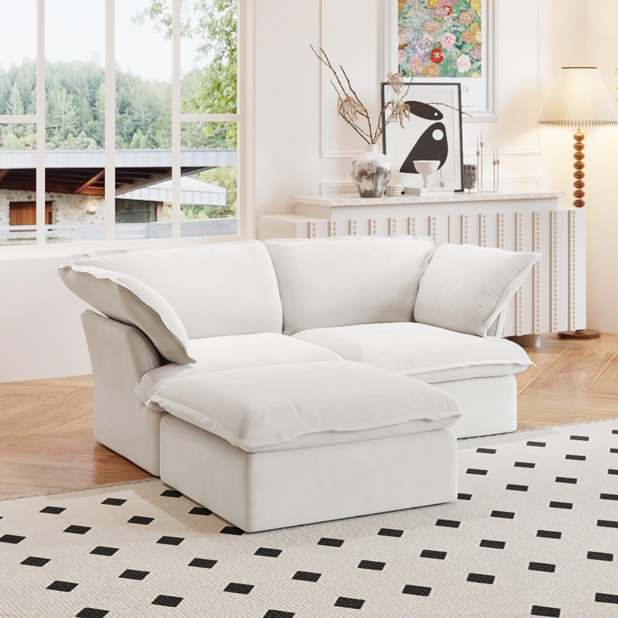 A white chaise lounge loveseat linen sectional sofa with a modular design and a storage ottoman, placed on a patterned rug in a bright living space.