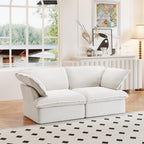 A white loveseat linen sectional sofa with modular design placed on a patterned rug in a bright living room setting.