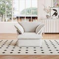 A white linen armchair with a solid frame and washable covers, placed on a patterned rug in a bright room.