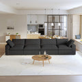 A modern black sectional sofa in a living room setting, featuring a 4-seater configuration with a modular design, down-filled cushions, and a clean, white color scheme.