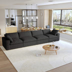 A modern black sectional sofa in a living room setting, featuring a 4-seater configuration with a modular design, down-filled cushions.