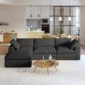 A black L-shaped modular sectional sofa with a storage ottoman in a modern living room setting.