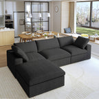 A black L-shaped modular sectional sofa with a storage ottoman in a modern living room setting.