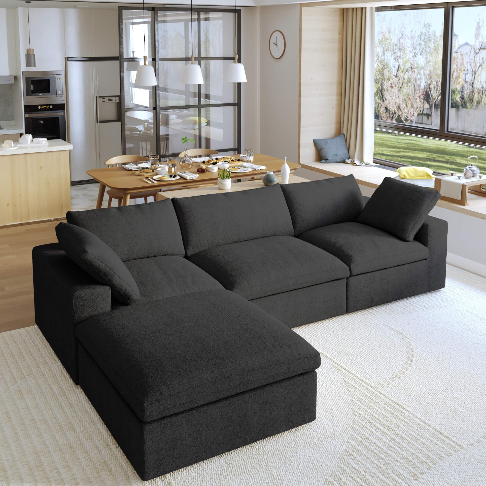 A black L-shaped modular sectional sofa with a storage ottoman in a modern living room setting.