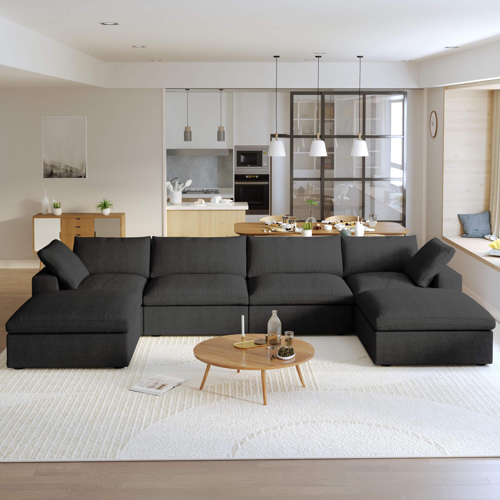 A large, U-shaped, black modular sectional sofa with storage ottoman in a modern living room setting.