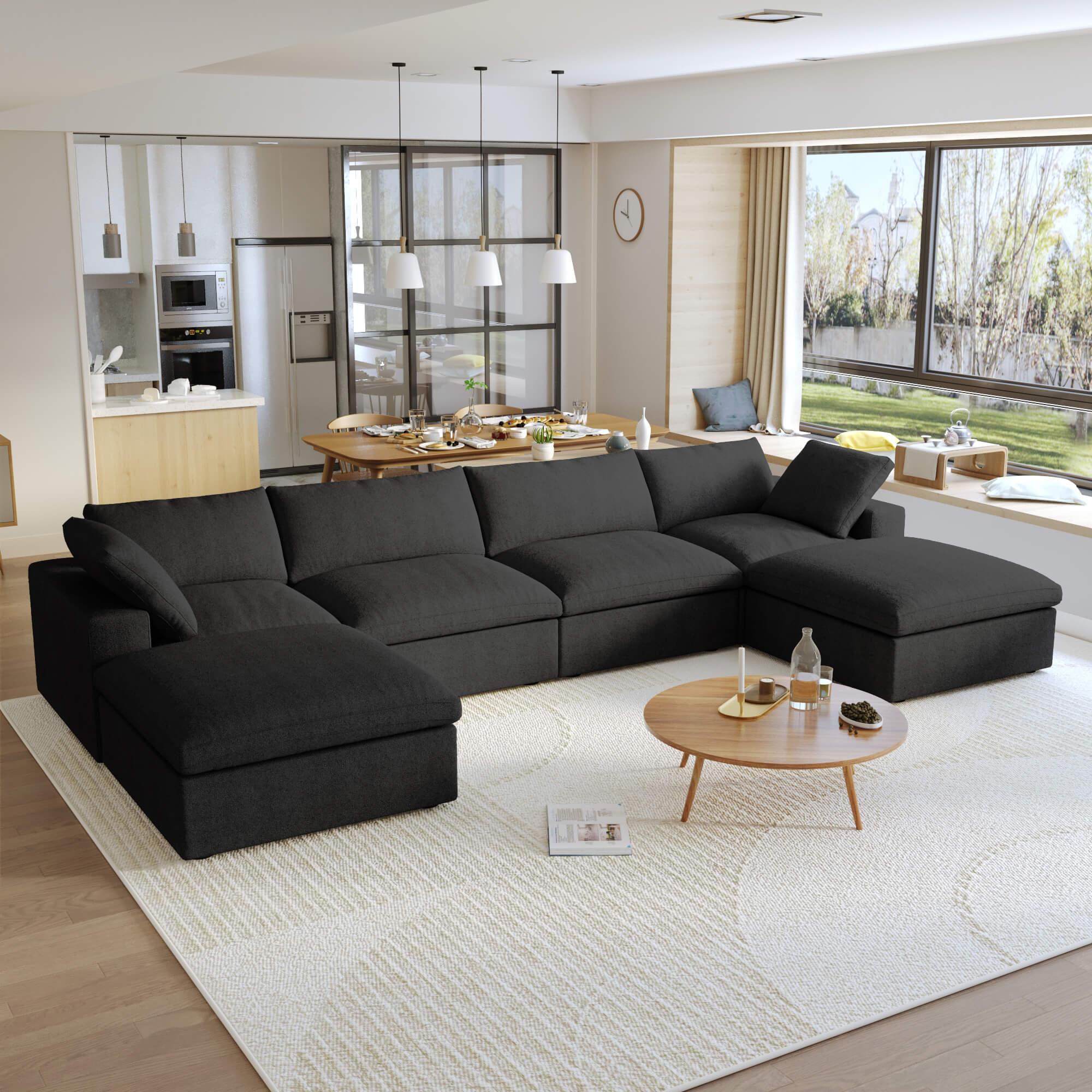 A large, U-shaped, black modular sectional sofa with storage ottoman in a modern living room setting.