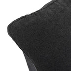 Close-up of a corner of a pillow of a black sofa