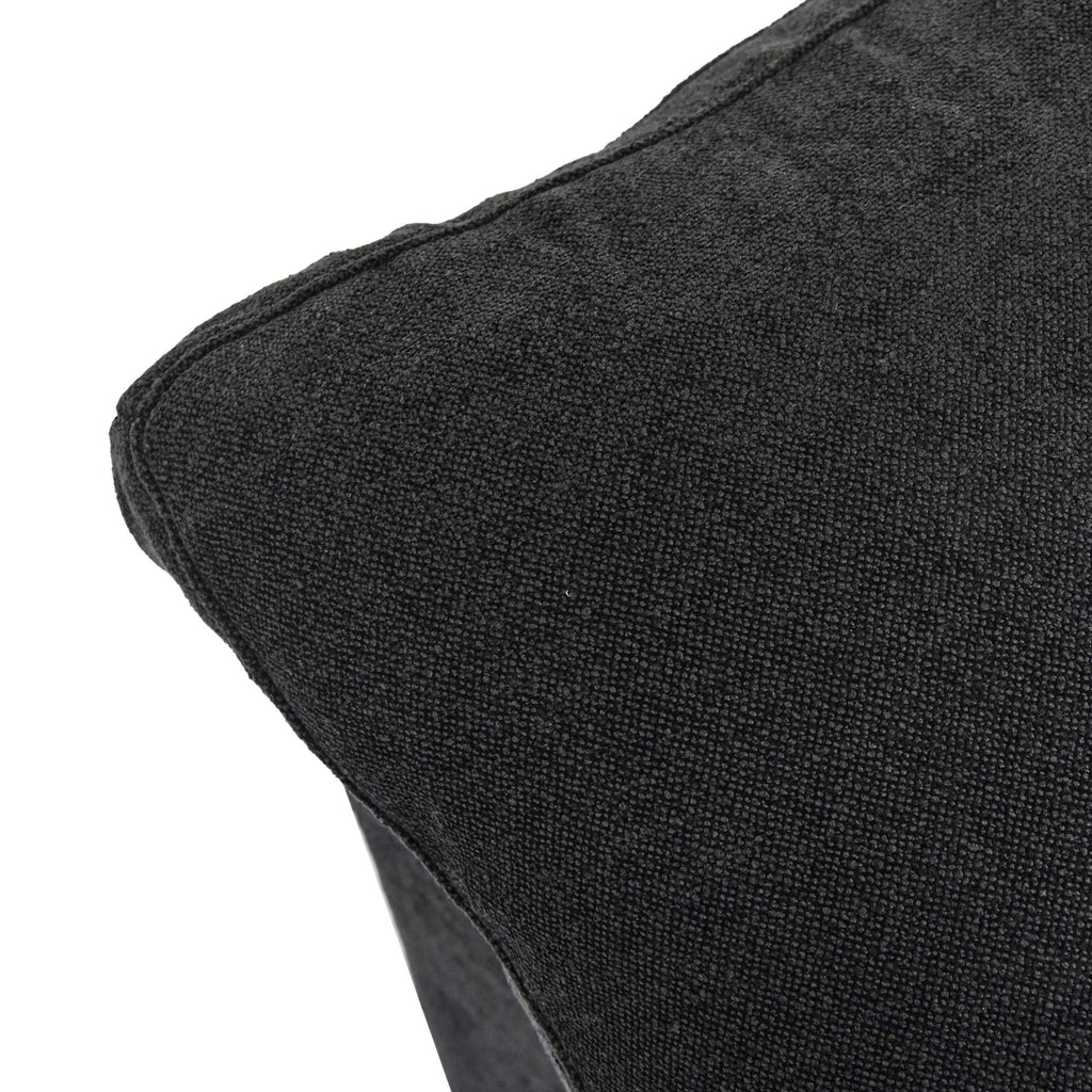 Close-up of a corner of a pillow of a black sofa
