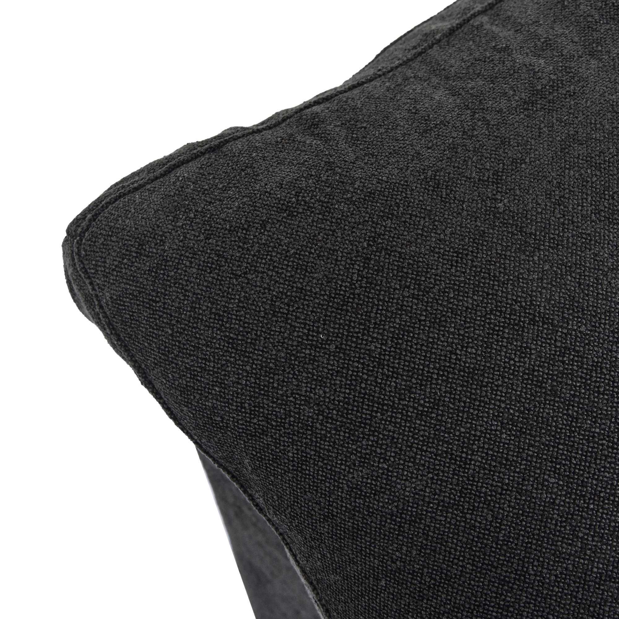Close-up of a corner of a pillow of a black sofa