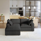 A black modular sectional sofa with a storage ottoman in a modern living room setting.